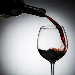 Czerwone wino nalewane do kieliszka. Czy czerwone wino jest zdrowe? Dyskusja trwa, ale jego piękny kolor zachwyca.
