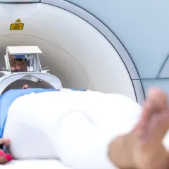 Pacjent leży w aparacie do rezonansu magnetycznego, przygotowując się do badania. Warto wiedzieć, jak przetrwać rezonans magnetyczny, by przejść przez niego spokojnie.